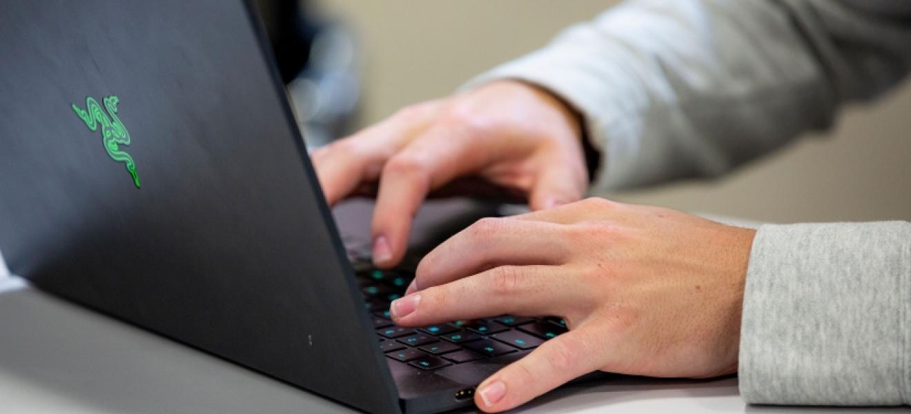 hands typing on a laptop keyboard