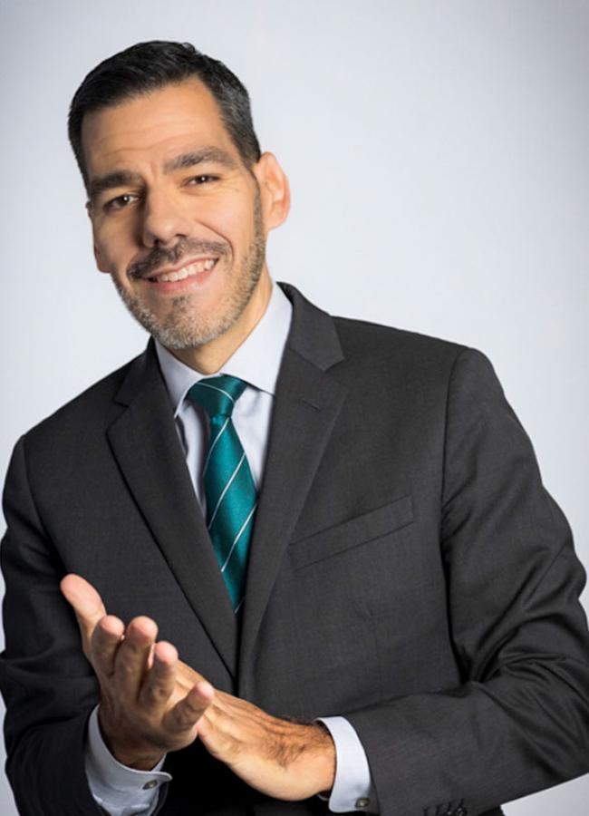 A headshot of a man clapping his hands. 