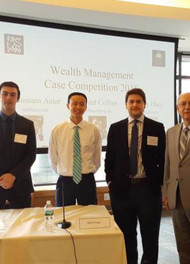 Hoosein Noorian poses with three students at a Wealth Management Competition