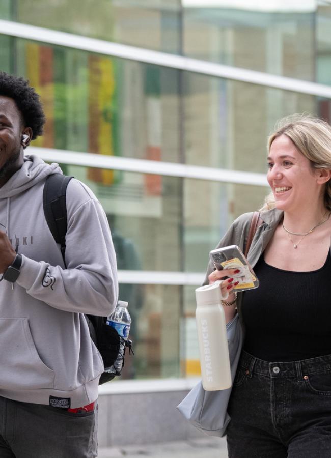 A man and woman walk next to Beatty hall on a spring afternoon.
