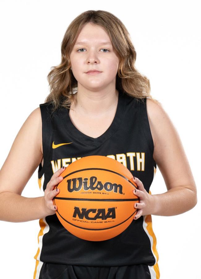 Kailee McPhillips wearing her Wentworth basketball team jersey and holding a basketball