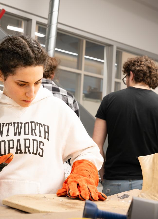a woman loads a fabricated award into a machine